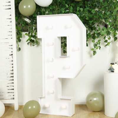 Large illuminated marquee letter "P" surrounded by greenery and balloons.