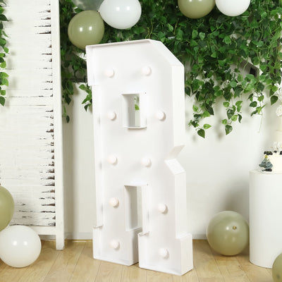 White marquee letter "R" with lights on a decorated background