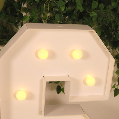 Decorative question mark light with warm yellow bulbs.