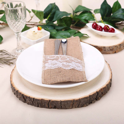 Elegant table setting with white plate, burlap napkin, and rustic wooden base.