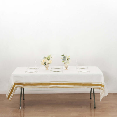 Elegant dining table set with flowers and tableware, featuring a striped tablecloth.