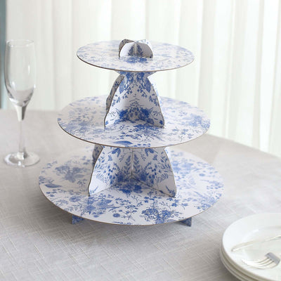 Three-tiered cake stand with blue floral design on a table setting.