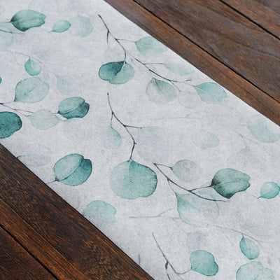 Watercolor leaf design runner on wooden surface.