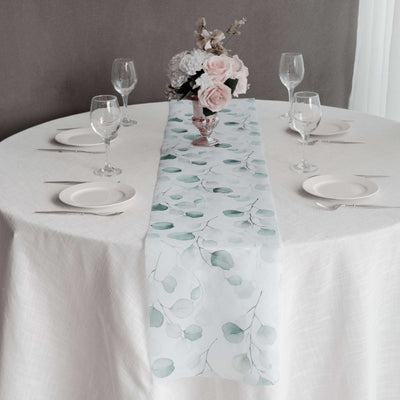 Elegant floral table runner on a dining table set for a meal.