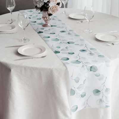 Table runner with green leaf design on a dining table setting.