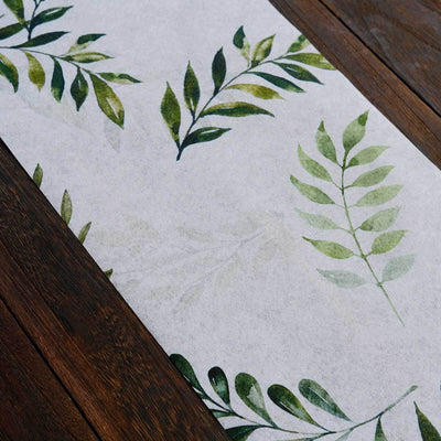 Leaf-patterned paper runner on a wooden surface.