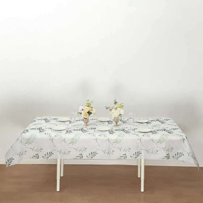 Table set with floral tablecloth and elegant dinnerware.