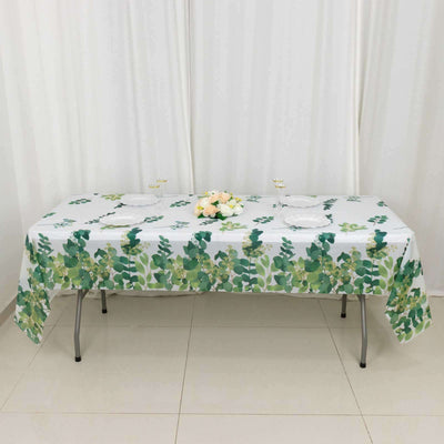 Floral tablecloth with green leaves design on a table setting.