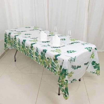 Floral tablecloth on a dining table with glasses and napkins.