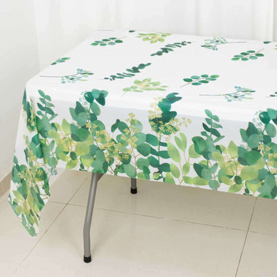 Floral-patterned tablecloth with green leaves on a white background.