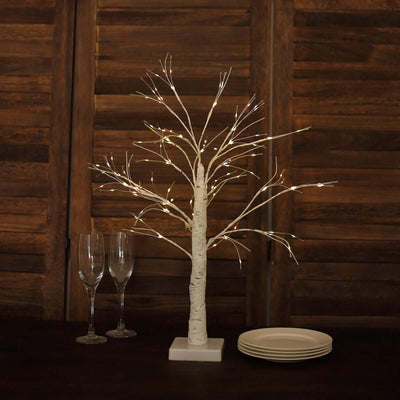 Decorative LED birch tree with lights on a wooden table setting.