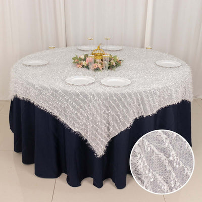 Round white tablecloth with fringe, styled for an elegant table setting.
