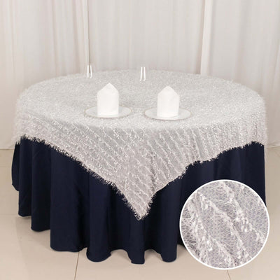 White textured tablecloth draped over a round navy table.