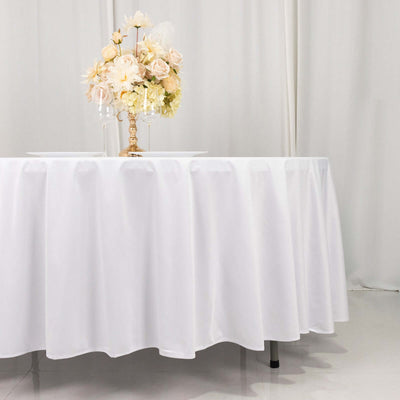 Elegant white tablecloth with floral centerpiece on a table.