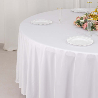 Elegant round table set with white tablecloth and floral centerpiece.