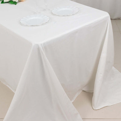 White tablecloth draping elegantly over a table with empty plates.