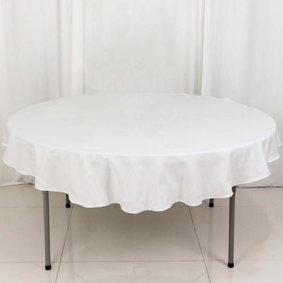 White round table with a ruffled tablecloth on a plain background