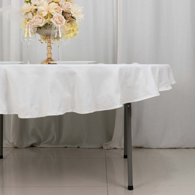 Elegant white tablecloth draping over a table with floral centerpiece.