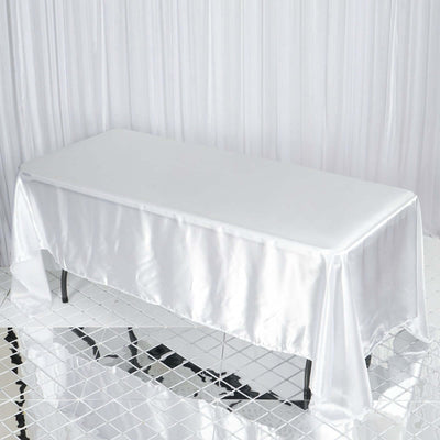 White satin tablecloth draped over a table in a studio setting