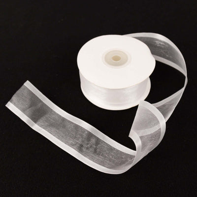 Clear ribbon spool with a flowing ribbon, perfect for crafts and decorations.