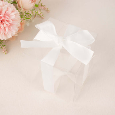 Clear gift box with white ribbon on soft background
