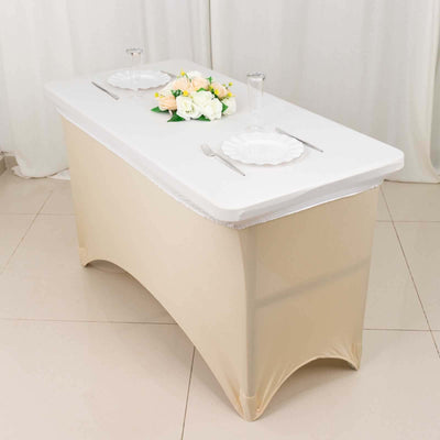 Elegant folding table with beige cover, set for dining with plates and flowers.