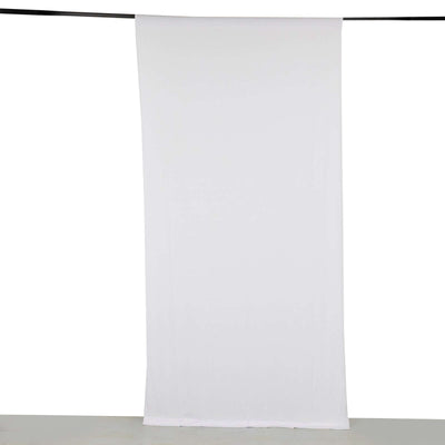 White fabric backdrop hanging on a rod for photography or staging use.