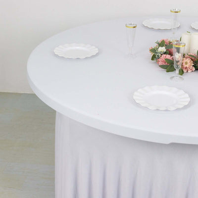 Round table set with white plates and floral centerpiece, ideal for dining.