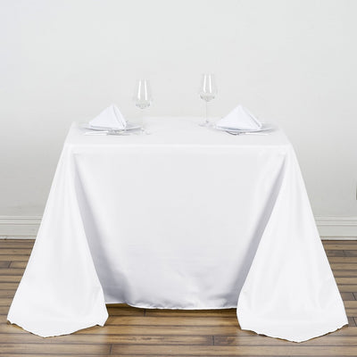 Elegant dining table set with white tablecloth and glassware