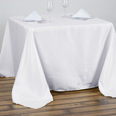 White tablecloth draping over a table set with glasses and napkins.