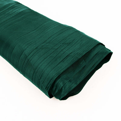 Green satin fabric roll with a textured surface, ideal for crafting and sewing.