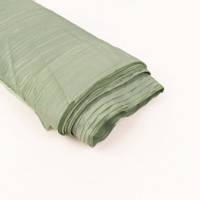 Wrinkled green fabric roll on a light background