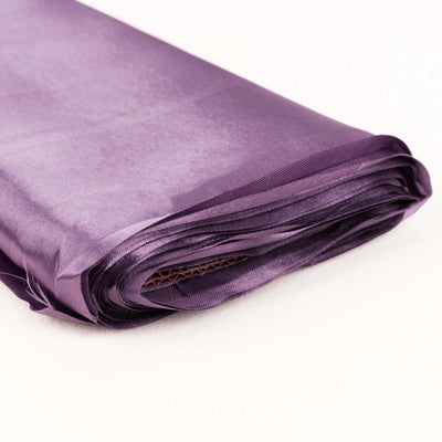 Purple satin fabric roll on a white background