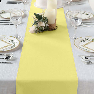 Yellow table runner on a dining table set for an elegant meal.