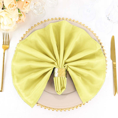 Elegant green napkin elegantly folded on a decorative plate setting.