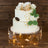Elegant two-tier cake with gold crown and floral decorations.