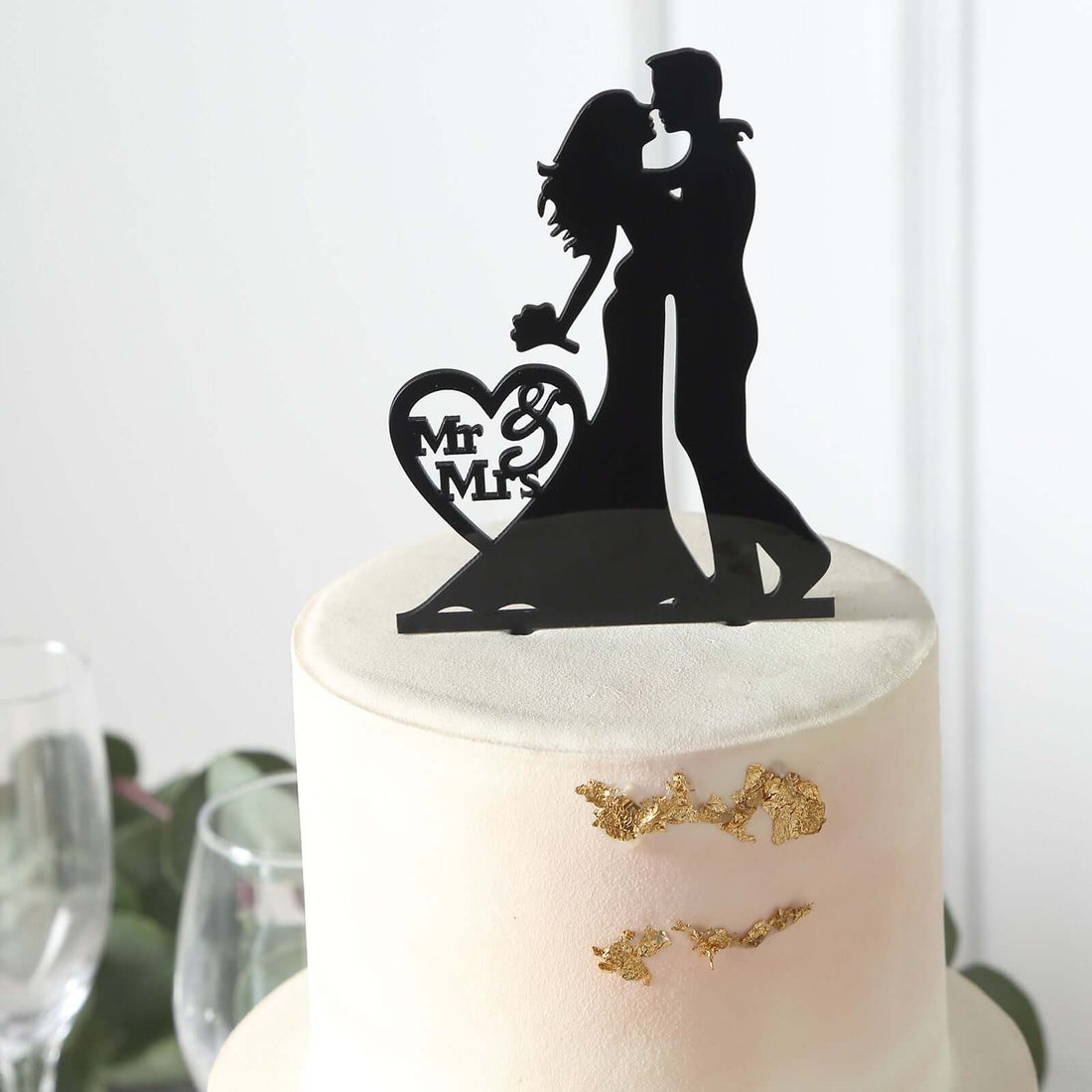 Bride and groom cake topper in black silhouette design.