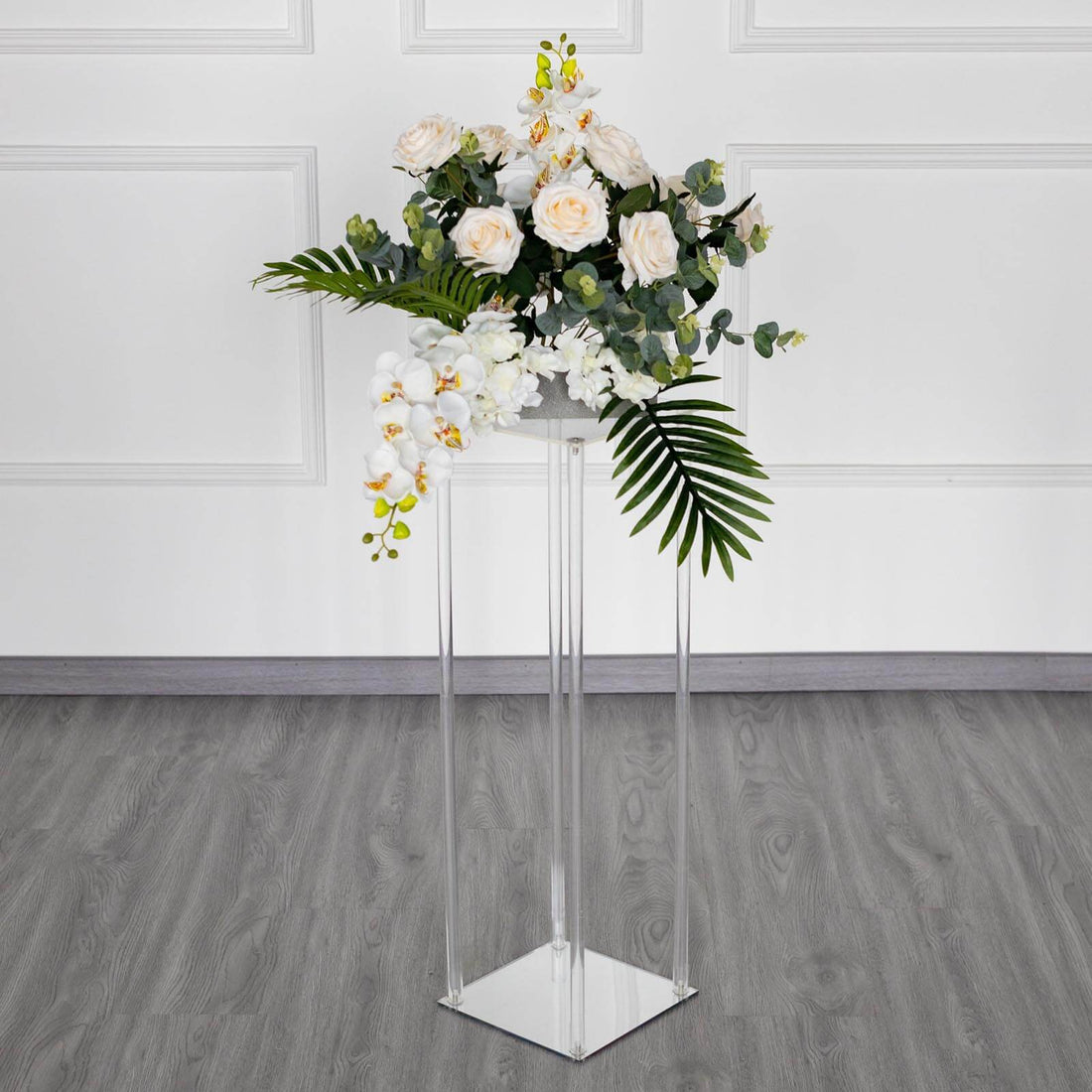 Elegant floral arrangement in a clear pedestal vase.