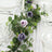 Elegant floral table runner with lavender roses and greenery for dining decor.