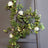 Artificial flower garland with LED lights on a wooden ladder.