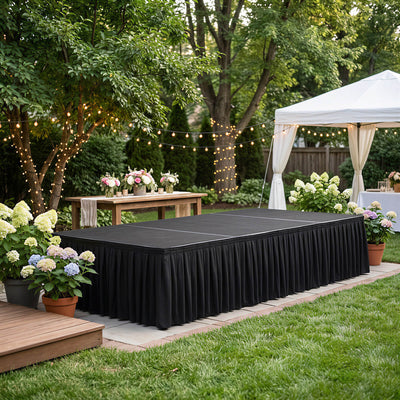 Backyard garden wedding stage with black skirted table and string lights