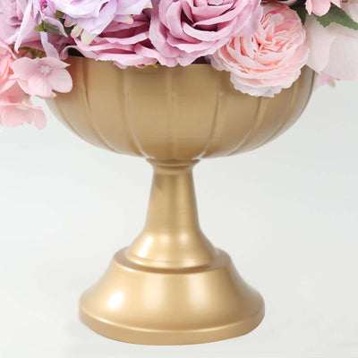 Gold decorative urn with pink flowers.