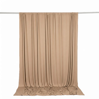 Beige draped curtain backdrop on a studio rod, neutral fabric background