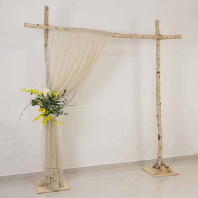 Wooden arch with draped fabric and floral arrangement