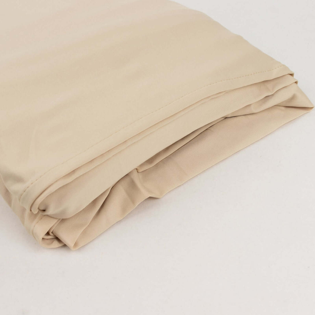 Folded beige fabric on a plain surface