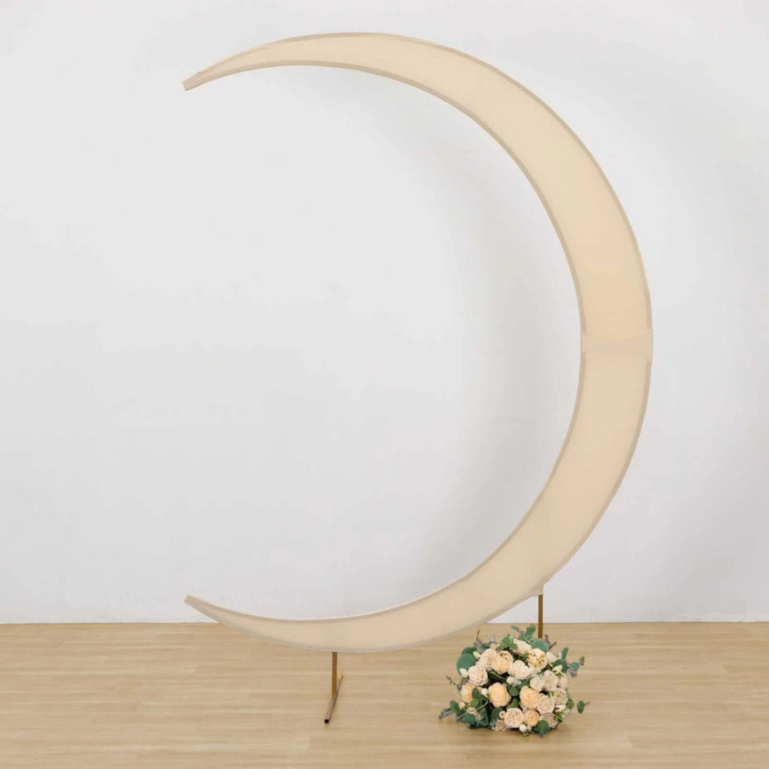 Moon-shaped backdrop with soft fabric and floral arrangements.