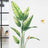 Leafy wall mural with birds in a bright, modern interior setting.