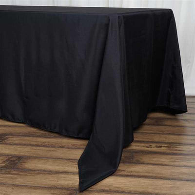 Black tablecloth draping over a table with a smooth finish.