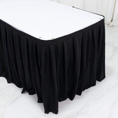 Black banquet table skirt on a white rectangular table in a bright room