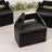 Black takeaway box with handle on a wooden surface.